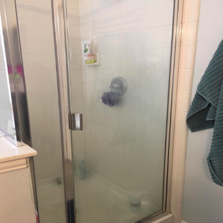 reviewer photo of dirty glass shower door 