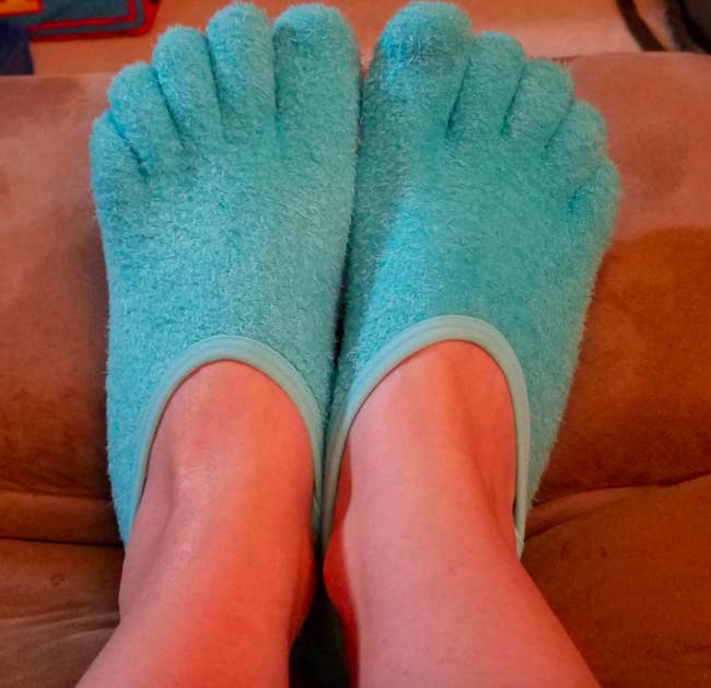 Blue moisturizing socks on reviewer's feet