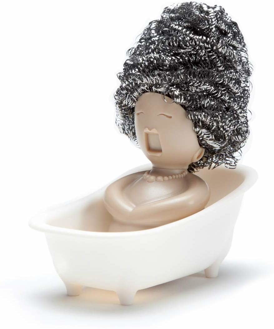 steel wool sitting on top of a handle which is shaped like the face and body of an opera singer. the steel wool is her curly hair. it&#x27;s sitting in a small container that looks like a tub.
