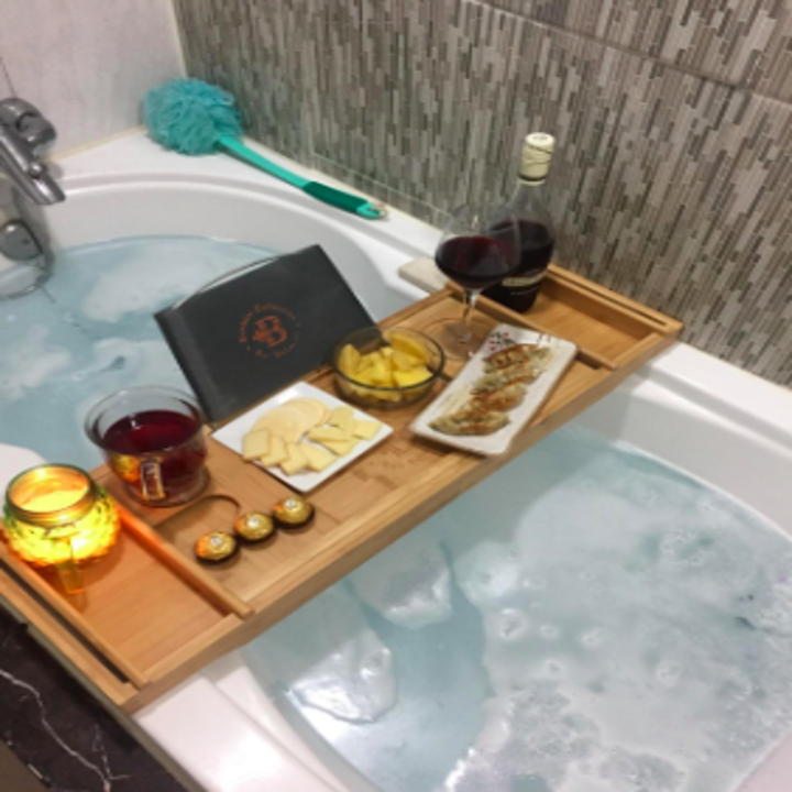 reviewer pic of the caddy holding wine, a candle, snacks