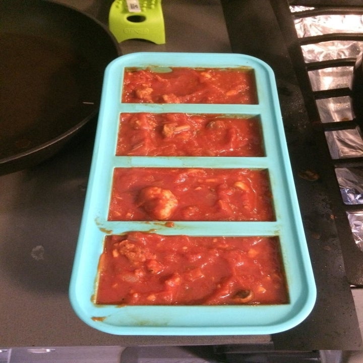 a reviewer photo of the freezing tray filled with pasta sauce
