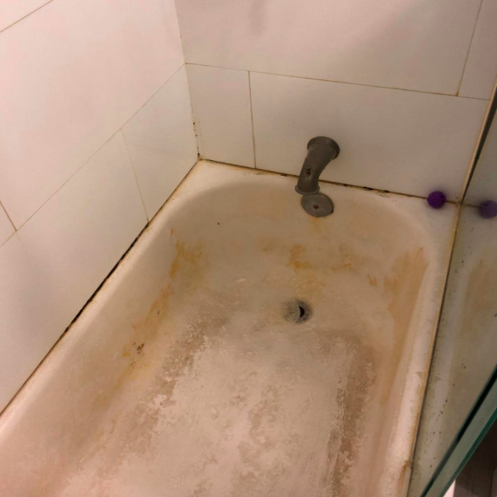 reviewer showing dirty bathtub