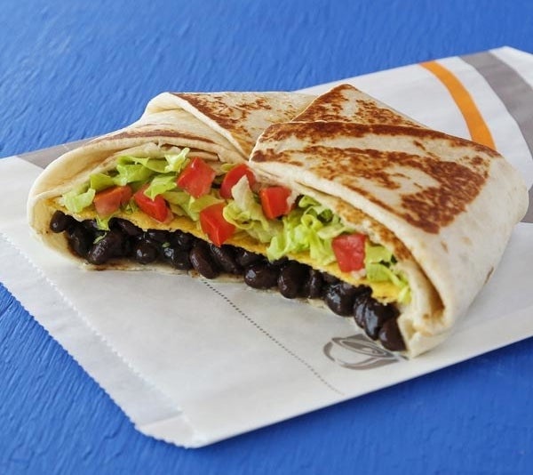 a crunchwrap supreme with beans, lettuce, and tomato in it