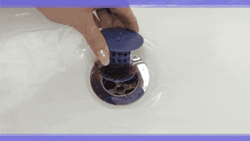 A GIF of a person pulling the silicone, mushroom-shaped product out of their drain. Hair is collected on the &quot;stem&quot; of the product, and the person just wipes it off. Text says &quot;It&#x27;s that easy!&quot;