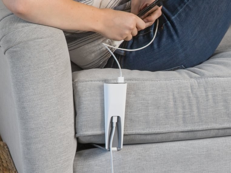 The triangle-shaped charger tucked under the couch cushion, with wires going up and down, connecting a phone to an oulet