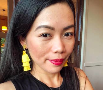 A reviewer wearing the earrings in yellow