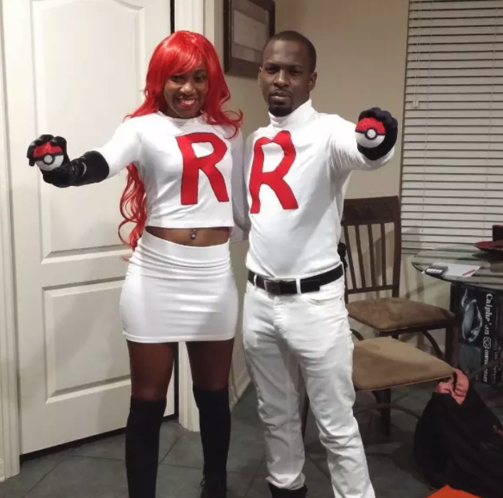 Two people dressed in Red Rocket uniforms while holding Poké Balls