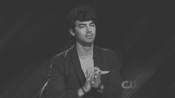 Joe Jonas in a suit clapping onstage with no rhythm or energy