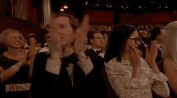 Wes clapping with his hands raised in front of his face