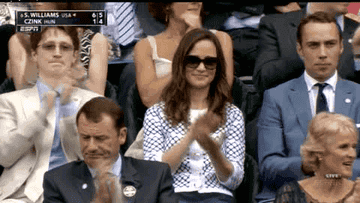 Pippa clapping in a crowd at a sporting event with one hand coming down on the other