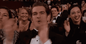 Andrew Garfield and others clapping in an audience at an event