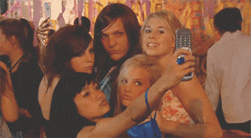 A GIF from &quot;Summer Heights High&quot; of Ja&#x27;mie and her friends trying to get a group selfie with a flip phone.