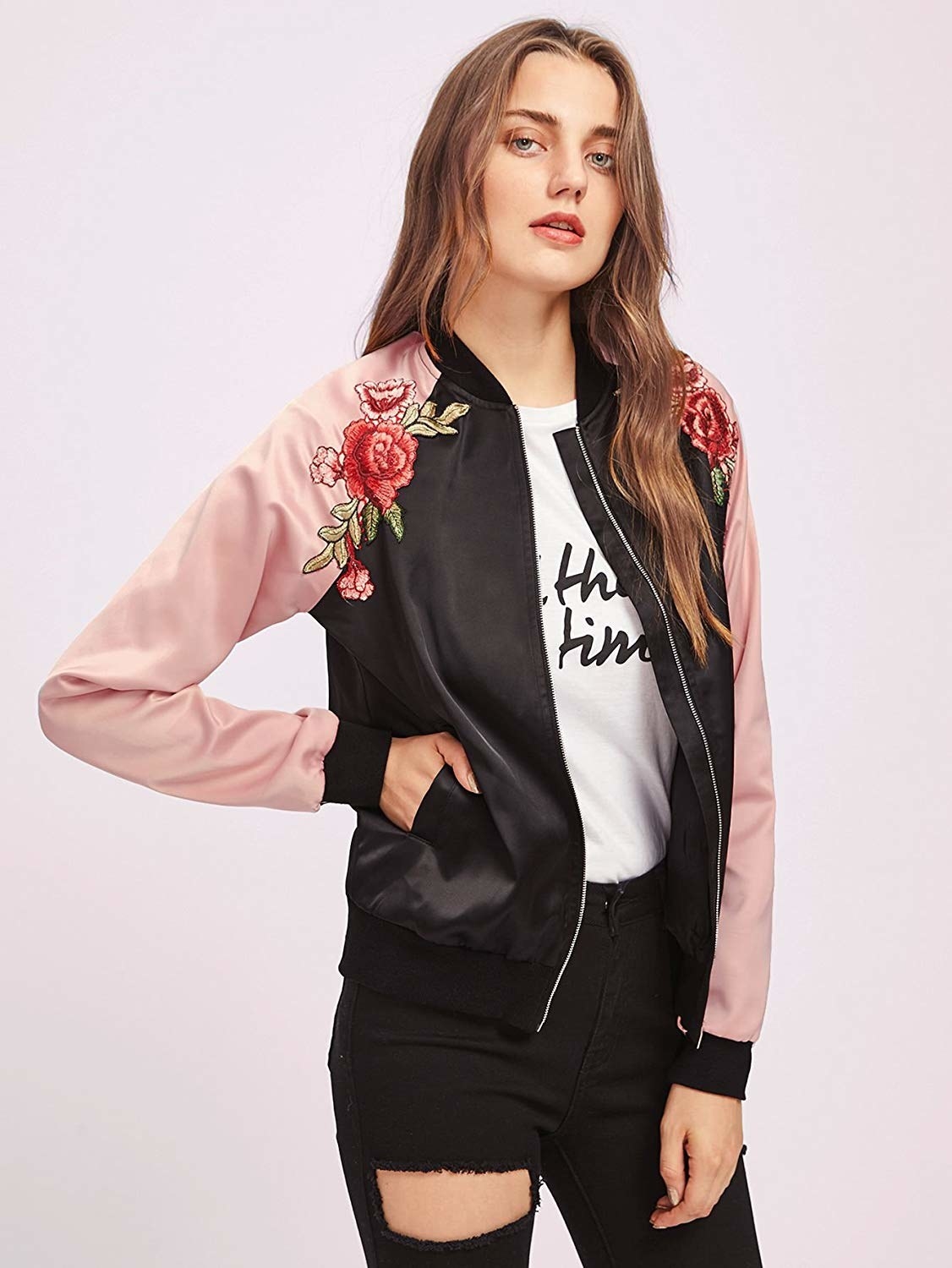 A model wearing the pink and black bomber with rose embroidery