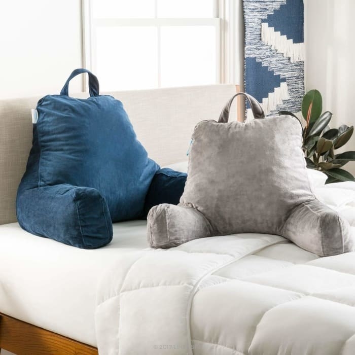 A blue and grey stand up pillow with arms and a handle on the top.