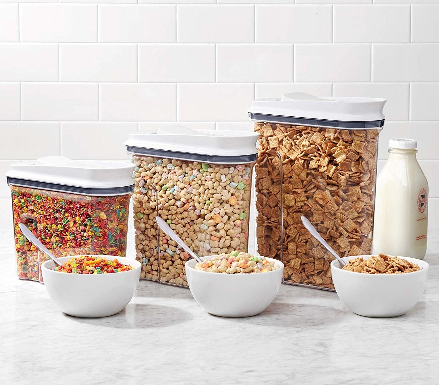 Three containers filled with different types of cereal 