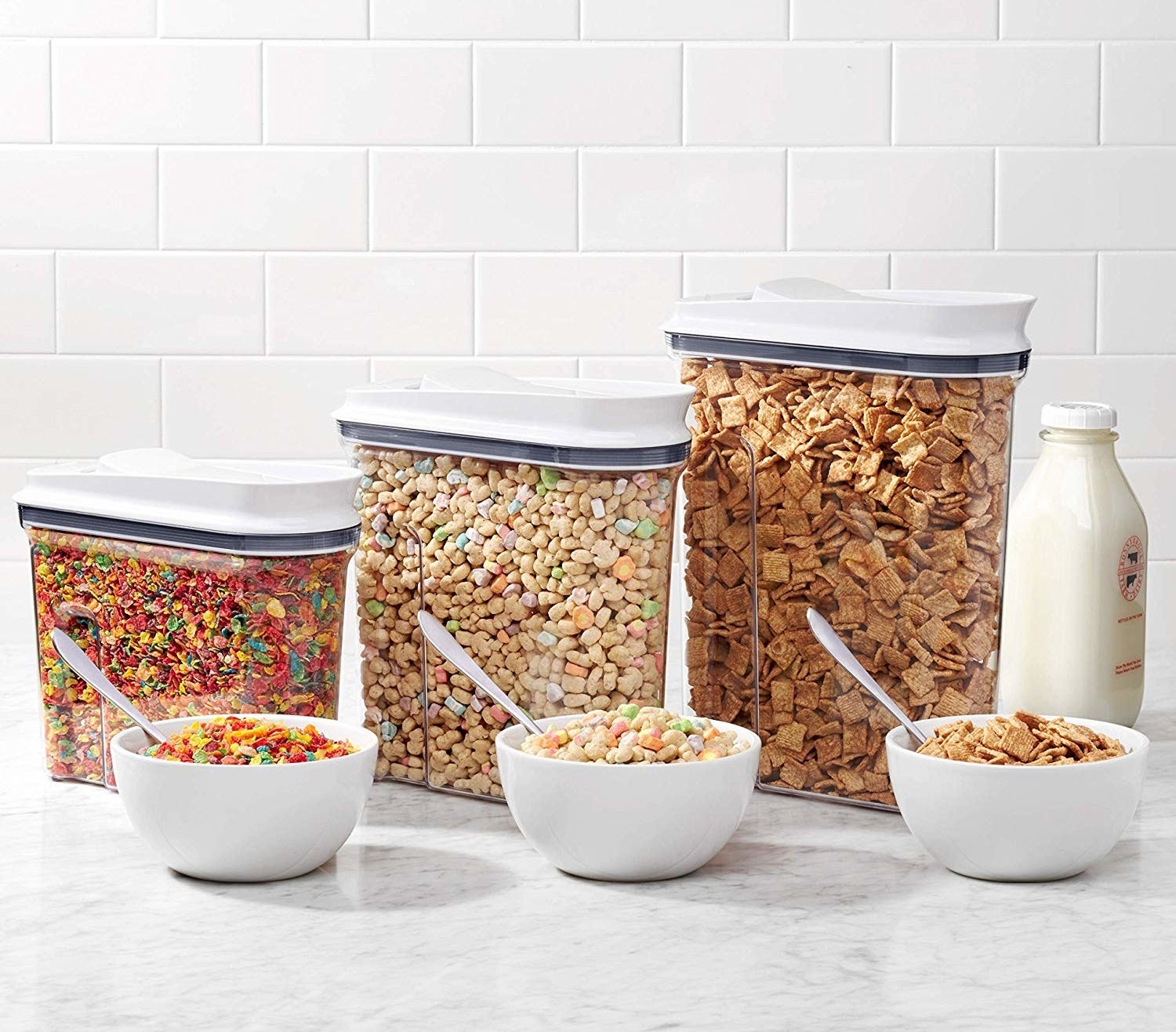 Three containers filled with different types of cereal 