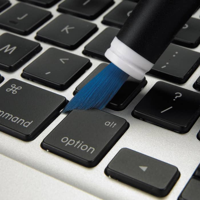 the brush being used on a black and silver keyboard