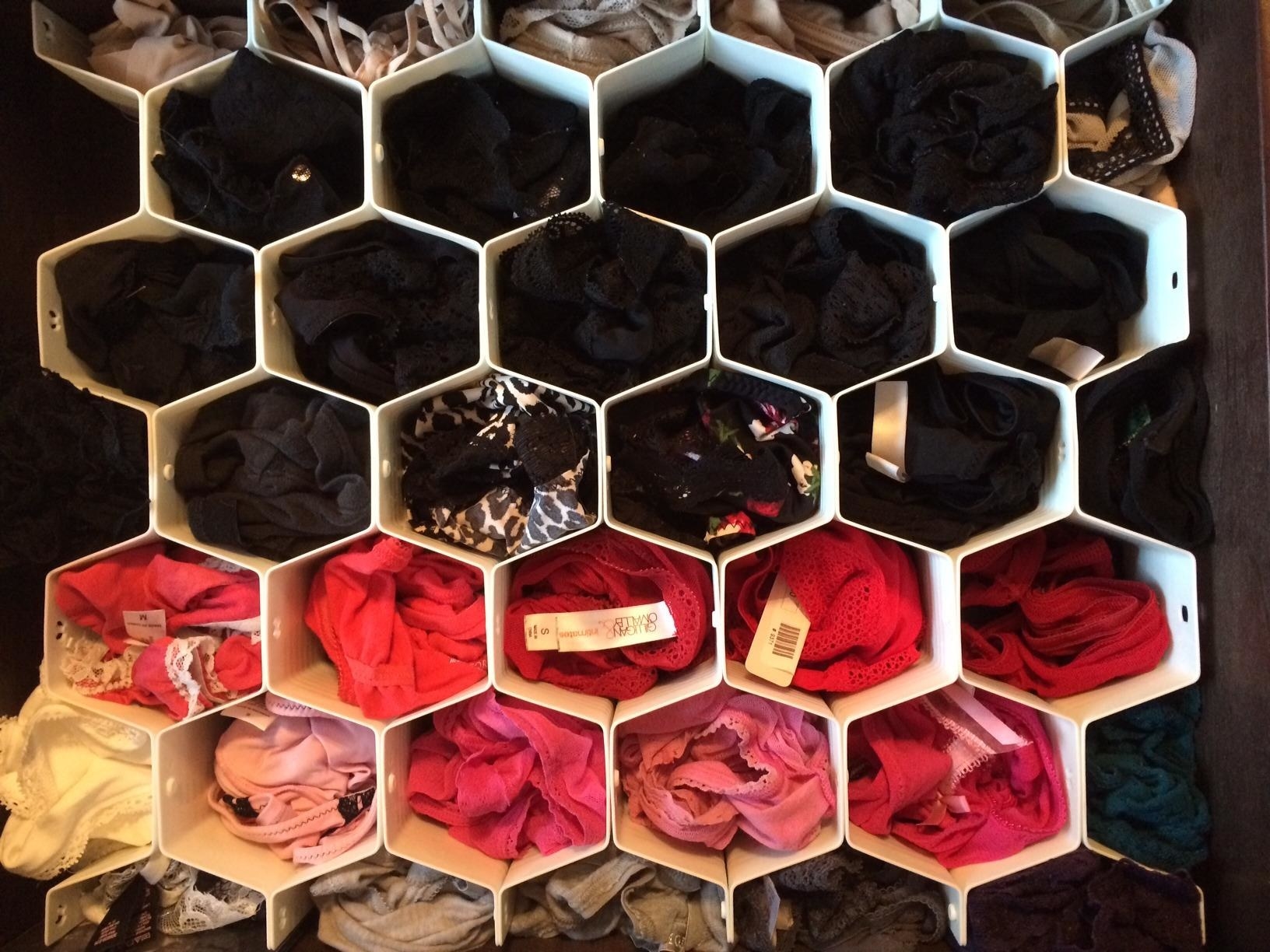 reviewer&#x27;s underwear drawer with small honey comb-shaped dividers separating each pair