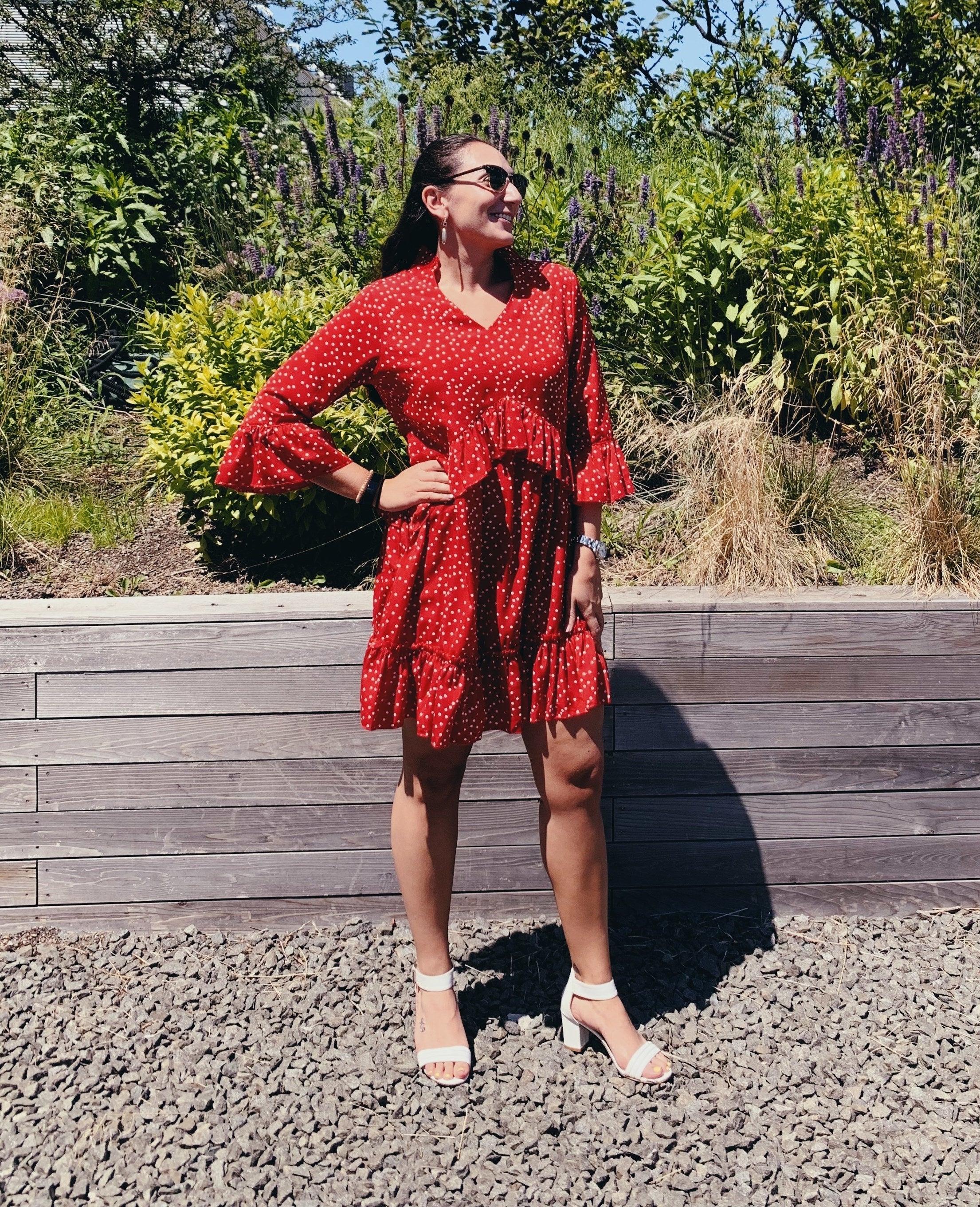 A person wearing the dress in front of a garden