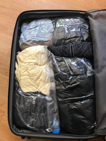 A reviewer's suitcase filled with the compact space-saver bags