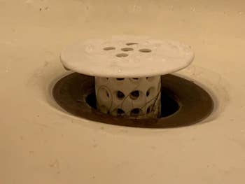 reviewer photo of the white tubshroom sitting inside a shower drain