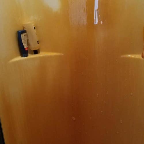 reviewer's pic of rust covered shower surround      