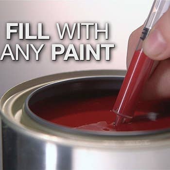 Hand with pen in paint bucket, filling it, syringe-like