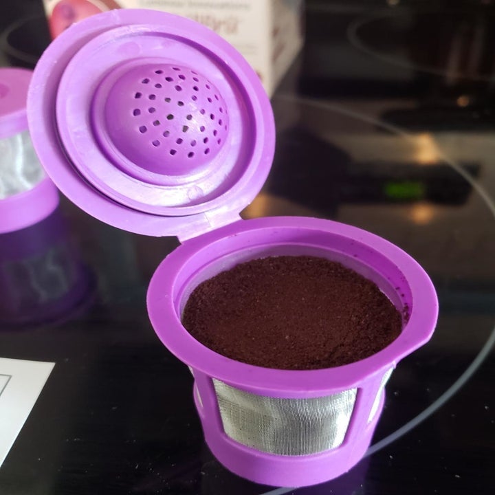 reviewer's purple plastic reusable pod full of ground coffee