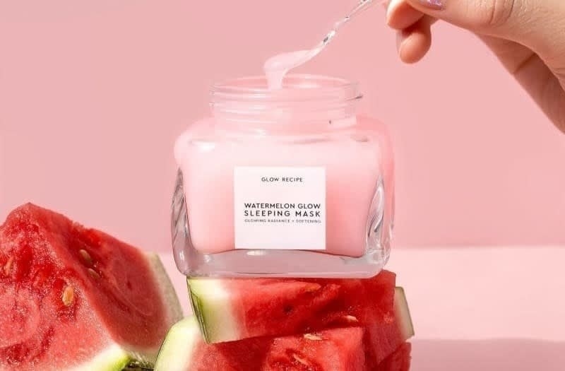 A person taking a spoonful of the watermelon sleep mask out of the jar