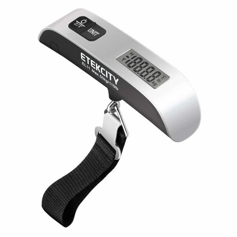 the silver luggage scale with black strap under it