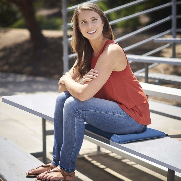 person sitting on a bleacher on the cushion