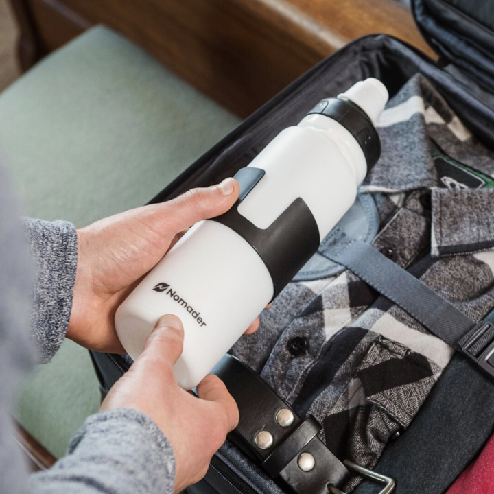 hands holding the water bottle in white, showing what it looks like at full size