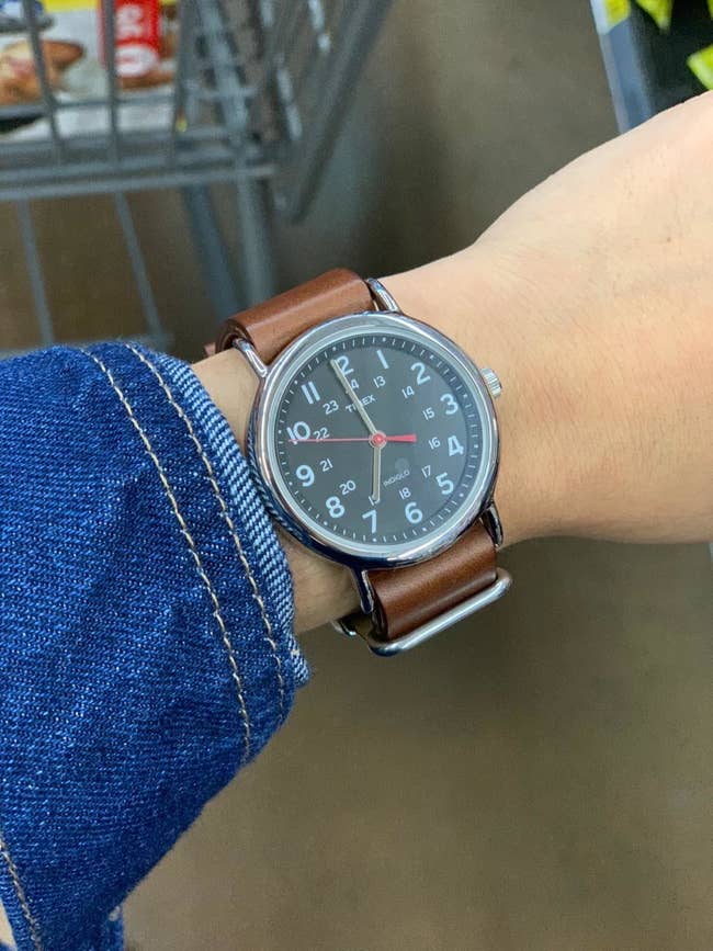 reviewer photo of a black dial watch on a brown leather strap