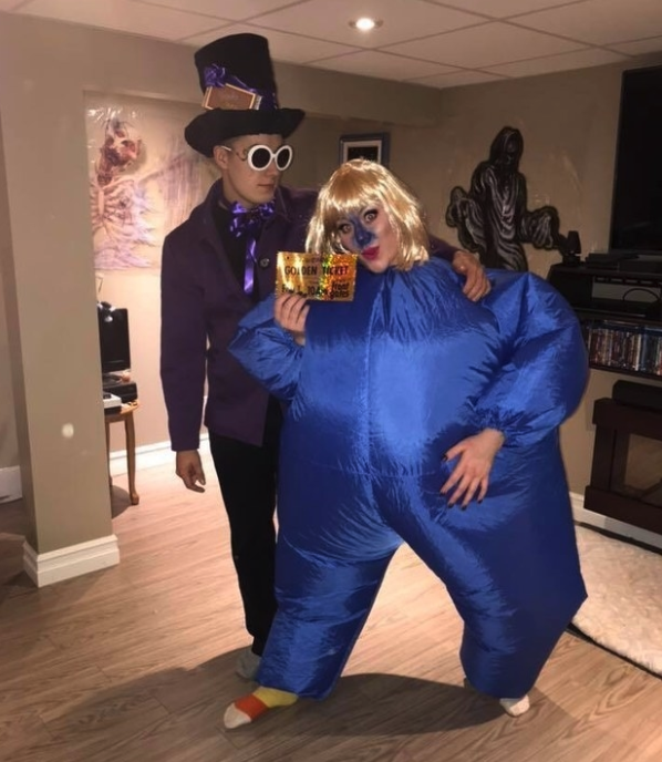 Someone in a blue inflatable suit and another dressed as Willy Wonka in a purple suit