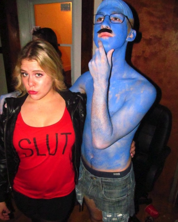 Someone dressed with blue paint on their body and another in a red shirt with &quot;slut&quot; written on it
