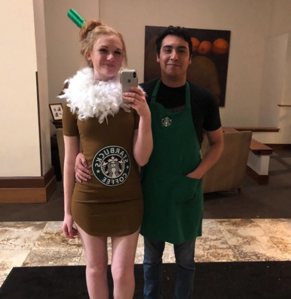Someone wearing a Starbucks apron and another wearing a brown dress with white feathers at the top as whipped cream