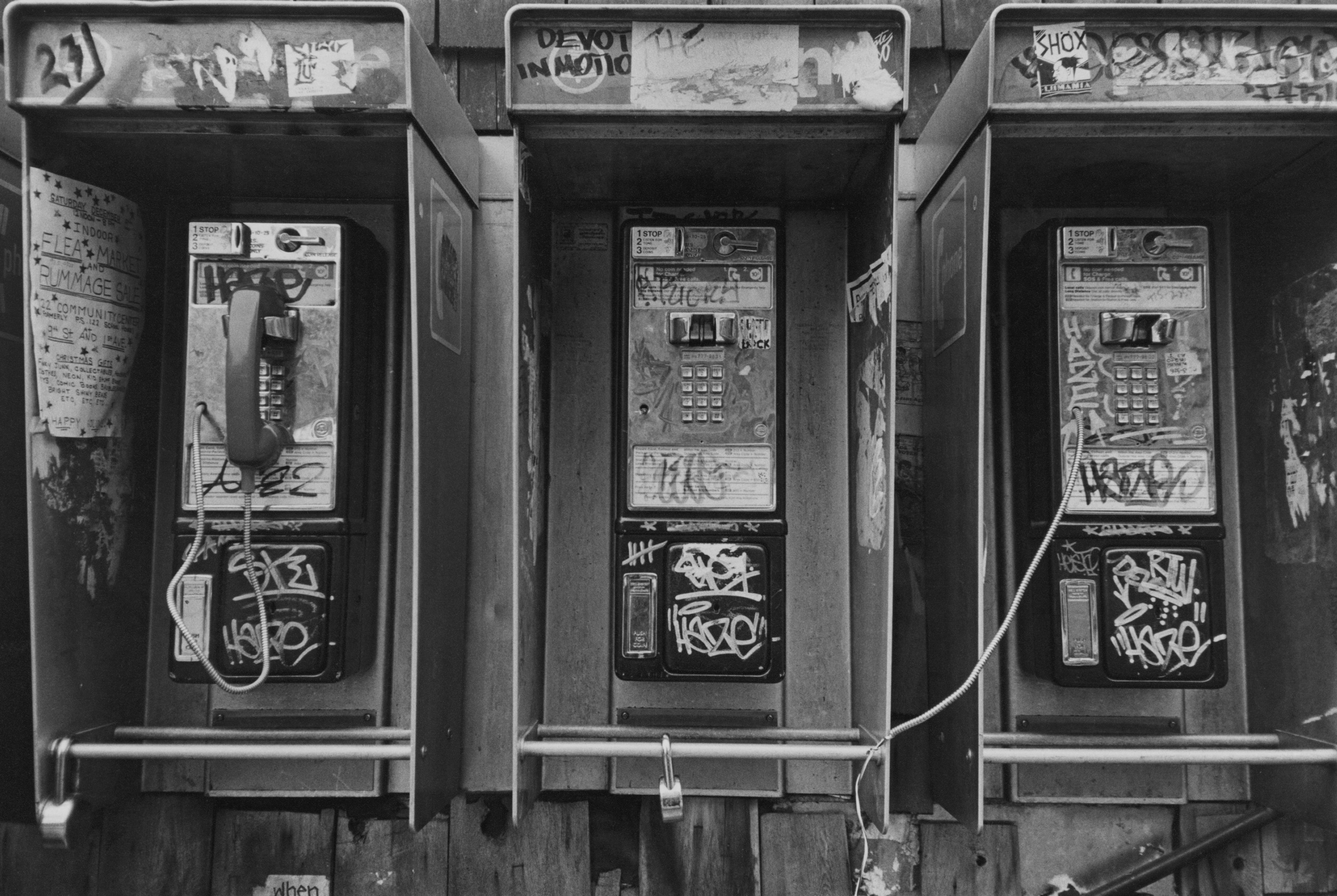 Black and white photo of dirty pay phones