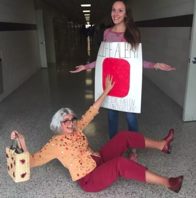 Someone dressed as an old lady who&#x27;s fallen, and another dressed as a Life Alert button