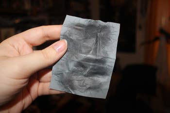 a reviewer holding the blot tissue showing how much oil was removed from the face