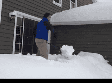 gif of person flinging snow from a pile with the two-handled spring shovel
