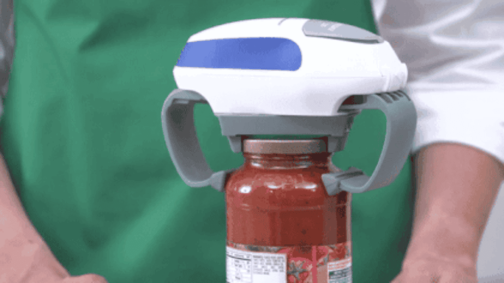 a moving gif of the jar opener clamped onto a jar of sauce, opening the lid