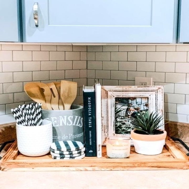 A reviewer photo showcasing the peel-and-stick tiles in white on the backsplash in the kitchen