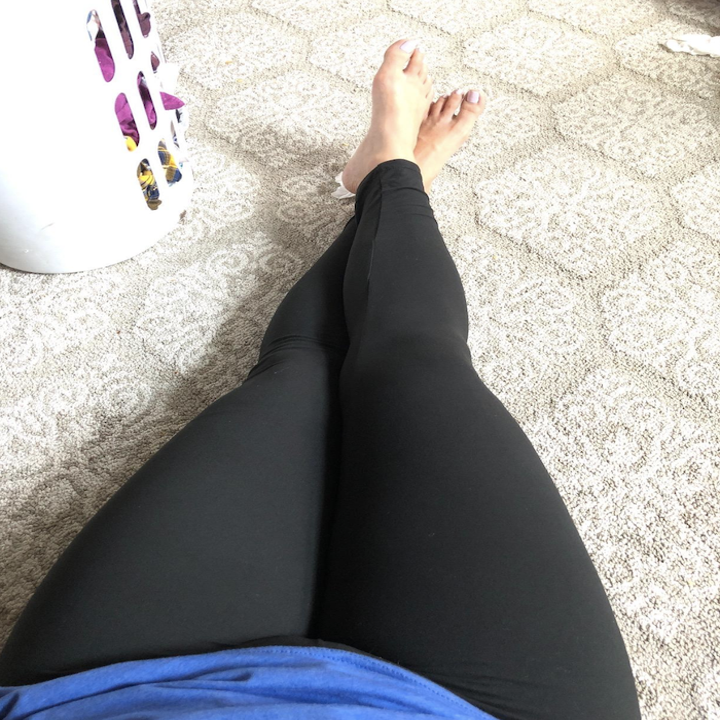 Reviewer sitting down on the floor wearing the leggings