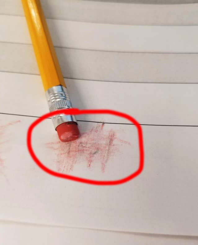 A pencil eraser with red marks on paper, circled in red ink