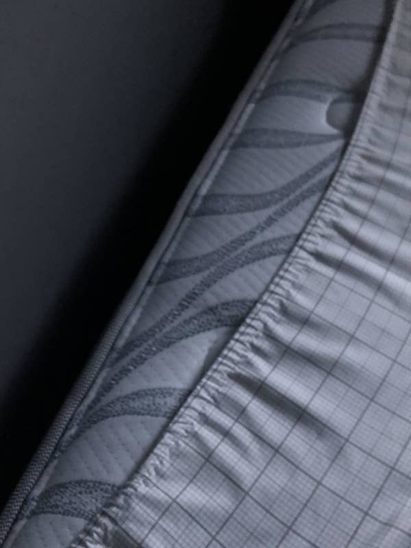 Close-up of a mattress with a quilted pattern and grid-like stitching