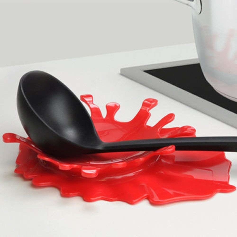 Spoon rest that looks like splash of red sauce 