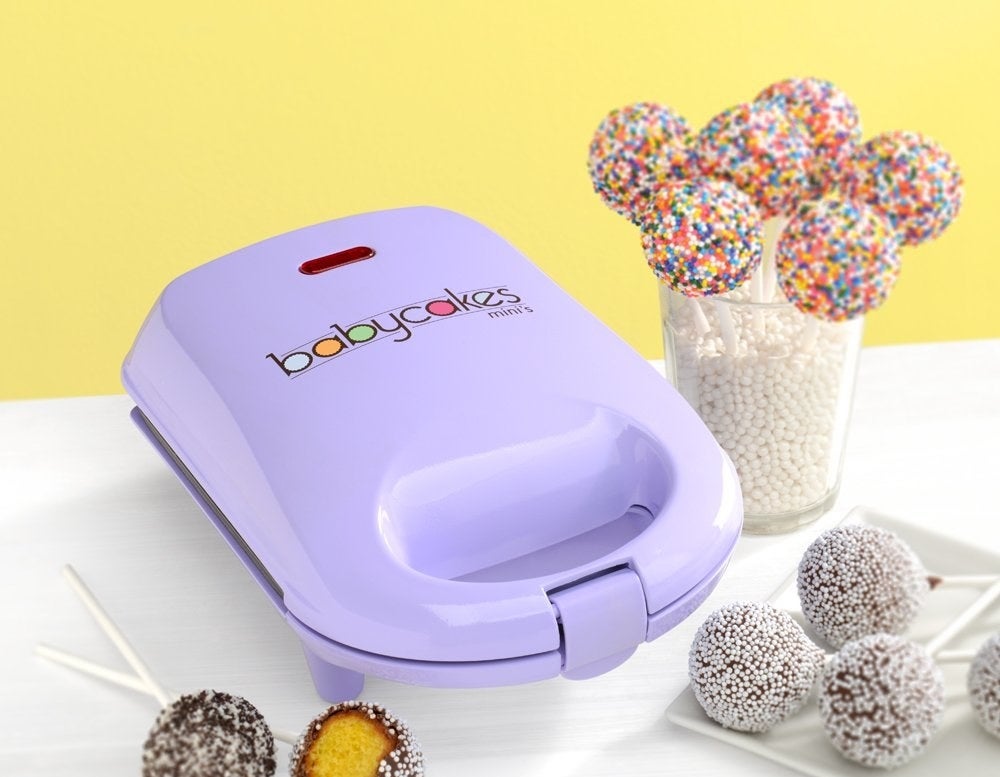 A rectangular flat plastic cake pop machine with a large handle on one end