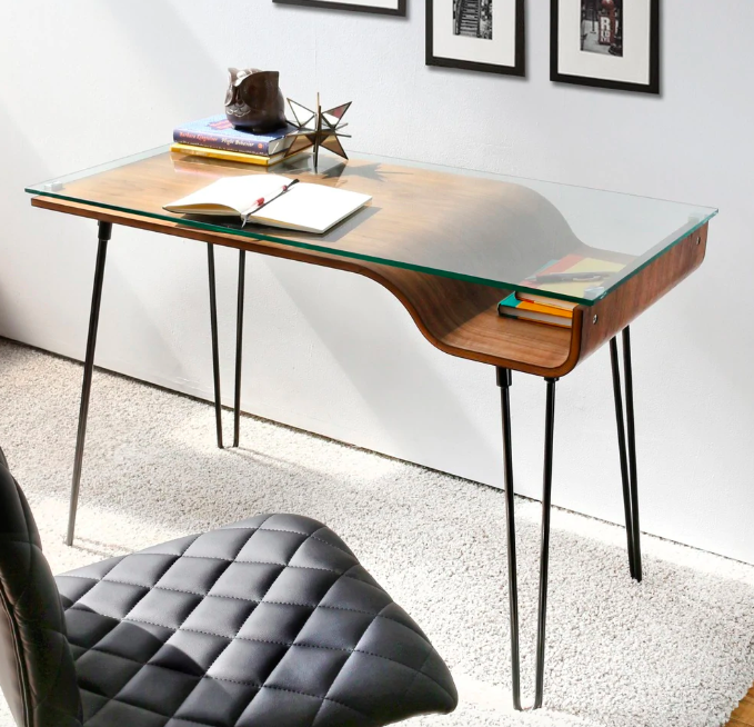 Curvy wood desk with glass surface and notebook on it 
