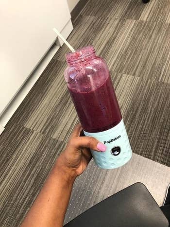 The same reviewer's personal blender with berries blended into a smoothie