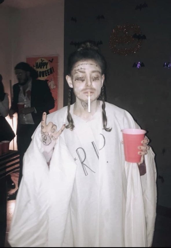 Someone dressed as post malone with a white sheet that says &quot;rip&quot;